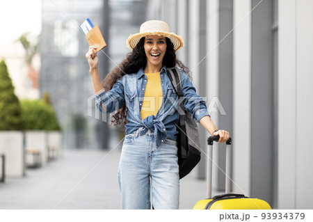Excited young woman going vacation alone, showing passport 93934379