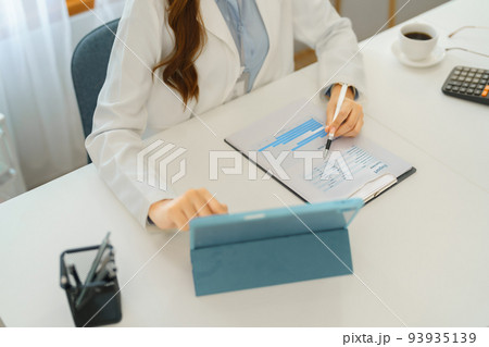Successful business concept, Businesswoman reading financial report on tablet and taking note data Successful business concept, Businesswoman reading financial report on tablet and taking note data 93935139