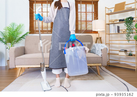 Housekeeping concept, Housemaid wear gloves and hold mop with cleaning supplies for cleanups house Housekeeping concept, Housemaid wear gloves and hold mop with cleaning supplies for cleanups house 93935162