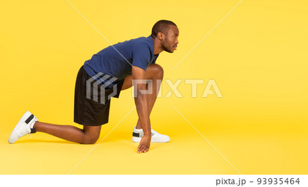 African Runner Guy Standing In Crouch Start Position, Yellow Background 93935464