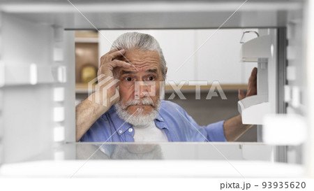 Portrait Of Hungry Elderly Man Searching For Food In Empty Fridge 93935620