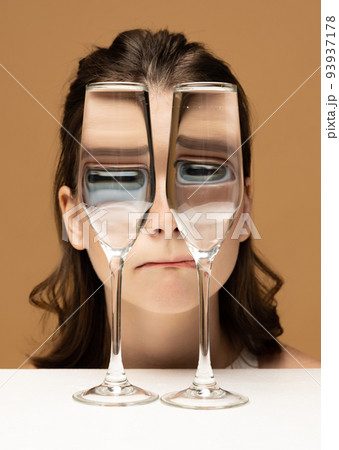 Contemporary art portrait of pretty girl looking through glass of water. Object distortion, optical illusion. Concept of art, creativity, surrealism. Closeup Contemporary art portrait of pretty girl looking through glass of water. Object distortion, optical illusion. Concept of art, creativity, surrealism. Closeup 93937178