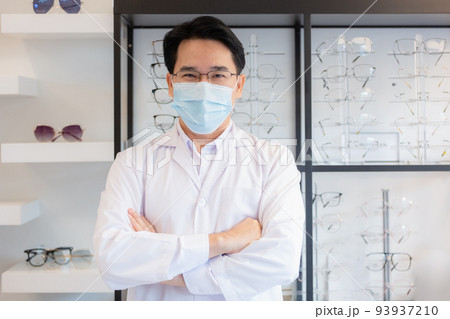 Man professional optician selling wear spectacles and protective face mask. 93937210