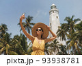 Selfie on Smartphone of Woman Traveler in Front of Famous Landmark of Sri Lanka Country of Dondra Lighthouse 93938781