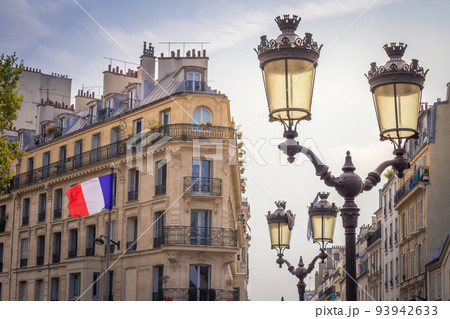 French flag winding and parisian architecture in Paris, France 93942633