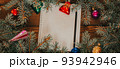 Christmas background with blank notebook for to-do list or wish list. with Christmas fir branches, decorations and gift boxes. Wooden rustic background for copy space photo banner 93942946