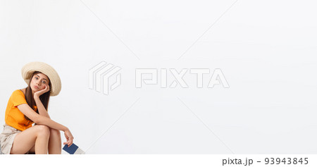 Lifestyle and travel Concept: Young beautiful caucasian woman is sitting on suitecase and waiting for her flight.Isolated over white background Lifestyle and travel Concept: Young beautiful caucasian woman is sitting on suitecase and waiting for her flight.Isolated over white background 93943845