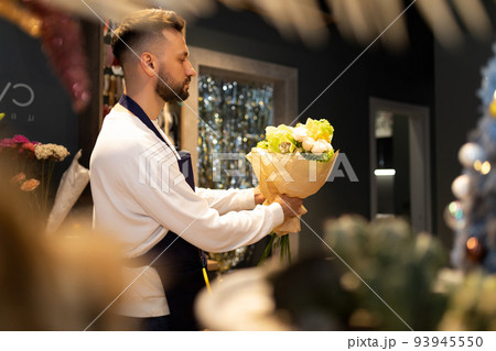 Bouquet designer in the workplace creates a composition of fresh flowers 93945550