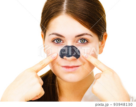 Woman applying pore strips on nose Woman applying pore strips on nose 93948130