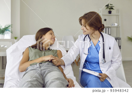 Friendly, supportive pediatrician and a happy teenage child holding hands and smiling Friendly, supportive pediatrician and a happy teenage child holding hands and smiling 93948342