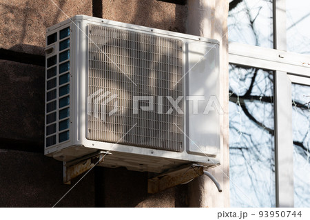 outdoor air conditioner unit with heat exchanger hanging outside the building 93950744