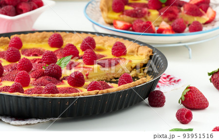 Round quiche with red strawberries and raspberries on a white table, top view Round quiche with red strawberries and raspberries on a white table, top view 93951516