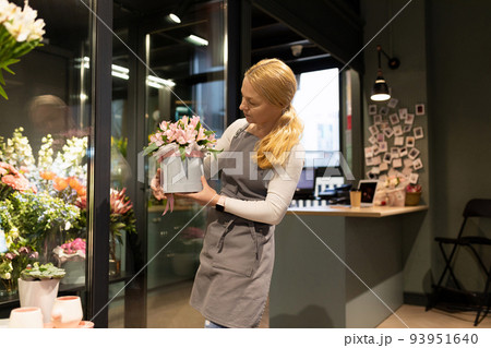 a young woman florist collects a bouquet for her regular client from natural flowers 93951640
