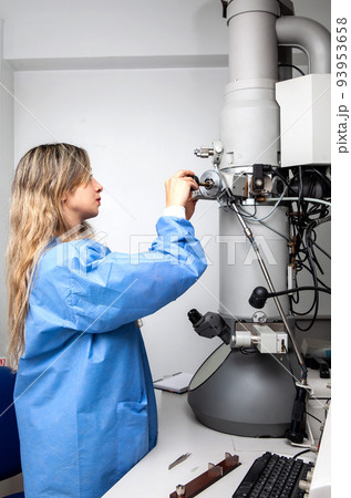 Young female scientist loading a specimen using a sample holder into a transmission electron microscope Young female scientist loading a specimen using a sample holder into a transmission electron microscope 93953658