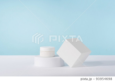 Cosmetic luxury cream jar bottle mockup on blue background on pedestal podium. Unbranded lotion beauty product packaging. Product presentation mock up. Cosmetic luxury cream jar bottle mockup on blue background on pedestal podium. Unbranded lotion beauty product packaging. Product presentation mock up. 93954698