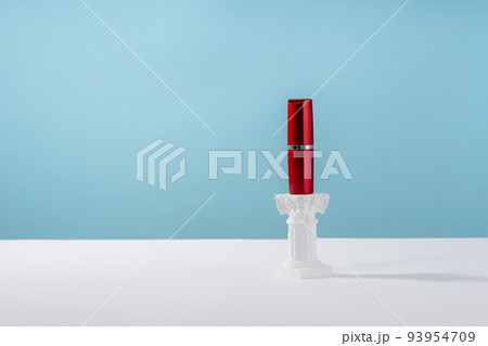 Red lipstick on roman marble column on blue background. Creative product stage mock up, cosmetic display podium platform or cosmetics product presentation, geometric stand 93954709