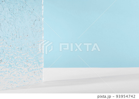 Acrylic ribbed plate, background for cosmetic product packaging on blue backdrop. Showcase for jewellery presentation, display for perfume advertising, cosmetics stand minimal branding scene Acrylic ribbed plate, background for cosmetic product packaging on blue backdrop. Showcase for jewellery presentation, display for perfume advertising, cosmetics stand minimal branding scene 93954742
