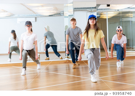 Teens dancing hip-hop dance together in dance hall 93958740