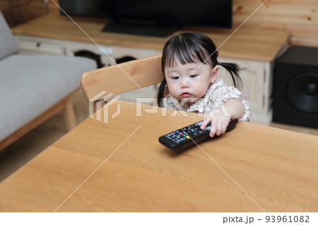 テレビのリモコンをいたずらする1歳の女の子 テレビのリモコンをいたずらする1歳の女の子 93961082