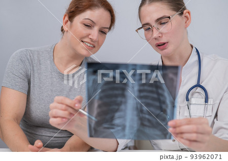 The doctor consults a caucasian woman and comments on the x-ray of the lungs. The doctor consults a caucasian woman and comments on the x-ray of the lungs. 93962071