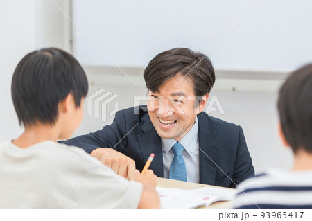 小学生に勉強を教える笑顔の塾講師・先生（日本人男性） 93965417