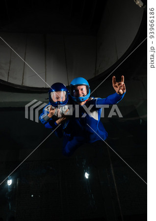 A man teaches a boy to fly in a wind tunnel. Lack of gravity. 93966186