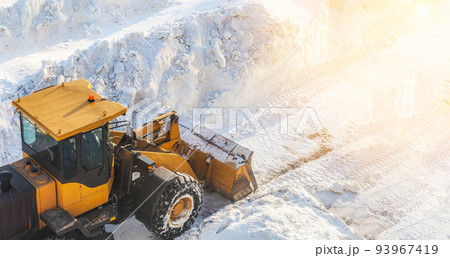 Big orange tractor removes snow from the road and clears the sidewalk 93967419