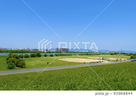 淀川河川敷公園　左岸土手の緑の草むらから遥かにグラウンドが見える景色　大阪市 93968844