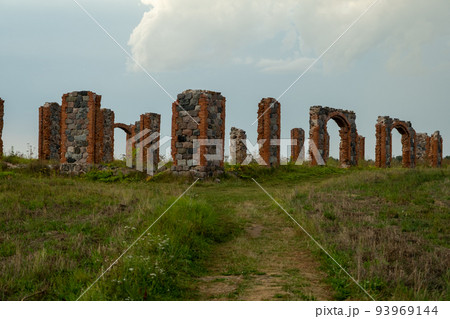 The remains of a stone column from an old building in the middle of a field on a sunny spring day. City Smiltene, Latvia. Old brick stonehenge The remains of a stone column from an old building in the middle of a field on a sunny spring day. City Smiltene, Latvia. Old brick stonehenge 93969144