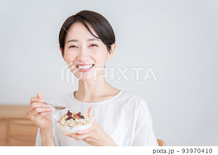 グラノーラを食べるミドル女性(朝食・食事・健康) グラノーラを食べるミドル女性(朝食・食事・健康) 93970410