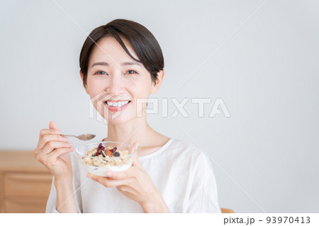 グラノーラを食べるミドル女性（朝食・食事・健康） 93970413
