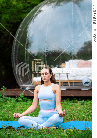 Transparent bubble tent and woman doing yoga at glamping 93973947