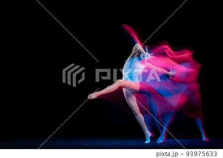 Ease of movement. Tender female ballet dancer dancing solo dance over dark background in mixed neon light. Art, flexibility, inspiration and beauty concept. 93975633