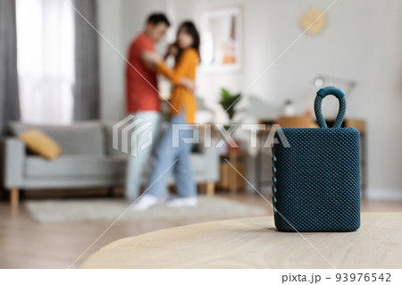 Selective focus on portable speaker over dancing couple 93976542