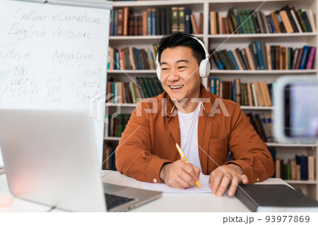 Chinese Teacher Taking Notes Teaching Online Via Laptop At Workplace 93977869