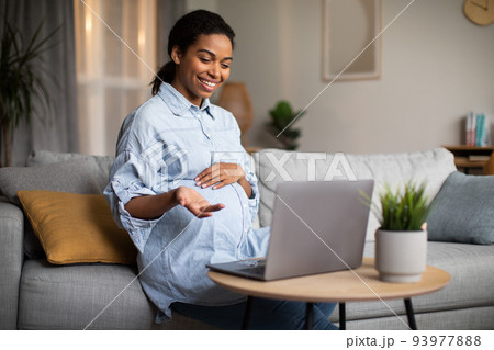 Pregnant African Lady Making Video Call Talking To Laptop Indoor Pregnant African Lady Making Video Call Talking To Laptop Indoor 93977888