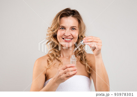 Skin Rejuvenation. Beautiful Middle Aged Female Holding Bottle With Face Serum Skin Rejuvenation. Beautiful Middle Aged Female Holding Bottle With Face Serum 93978301