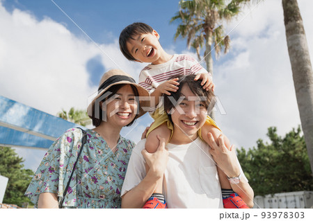 夏の家族旅行・肩車をするファミリーイメージ 93978303