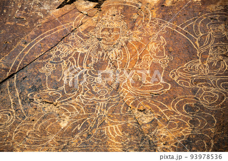 An ancient Buddha image on a stone rock. UNESCO World Heritage Site 93978536
