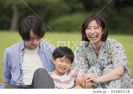 公園でレジャーシートに座るファミリーイメージ 93980218