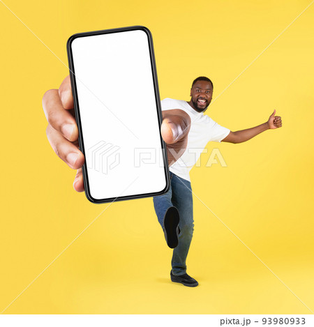 Cheerful Black Man Showing Cellphone Screen Over Yellow Background, Square 93980933