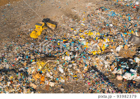 Excavator collects garbage from a landfill for recycling. Ecological catastrophe due to non biodegradable waste and plastic Excavator collects garbage from a landfill for recycling. Ecological catastrophe due to non biodegradable waste and plastic 93982379