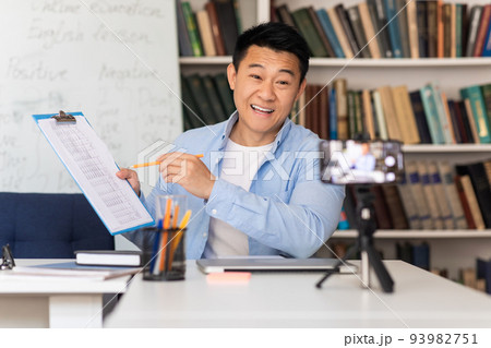 Korean Male Teacher Having Virtual Lecture Talking To Cellphone Indoor Korean Male Teacher Having Virtual Lecture Talking To Cellphone Indoor 93982751