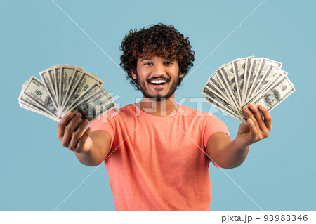 Happy indian man holding cash in both hands and smiling 93983346