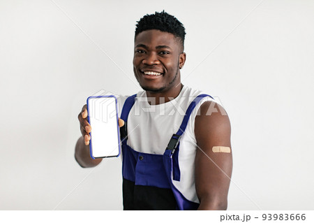 Happy Vaccinated African American Male Worker Showing Cellphone Screen, Studio 93983666
