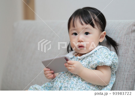 スマホで遊ぶ1歳の女の子 93983722