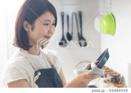 お皿を拭く笑顔の女性 お皿を拭く笑顔の女性 93984439