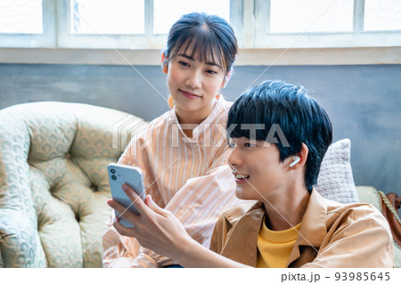 スマホで音楽を聴く若いカップル スマホで音楽を聴く若いカップル 93985645
