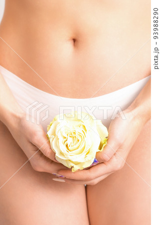 Caucasian woman in white panties with white rose flower on a uniform background, closeup Caucasian woman in white panties with white rose flower on a uniform background, closeup 93988290