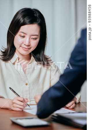 契約書にサインをする若い女性 契約書にサインをする若い女性 93988456
